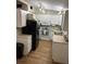 Cozy kitchen features white cabinets, appliances, track lighting, and wood-look vinyl flooring at 4024 Canal Rd, Lake Wales, FL 33898