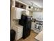 Cozy kitchen features white cabinets, appliances, track lighting, and wood-look vinyl flooring at 4024 Canal Rd, Lake Wales, FL 33898