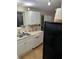 The kitchen has white cabinets and appliances, double sinks, and wood-look vinyl flooring at 4024 Canal Rd, Lake Wales, FL 33898