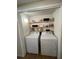 This laundry room has a washer, dryer, and shelving with decorative wallpaper at 4024 Canal Rd, Lake Wales, FL 33898