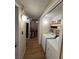 Hallway view of the laundry room with a washer, dryer, and shelving along with living room and seating at 4024 Canal Rd, Lake Wales, FL 33898