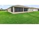 View of the home's backyard with lush green grass and a screened lanai at 4073 Sable Loop Dr, Lake Wales, FL 33859