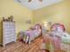 Charming bedroom featuring twin beds with colorful quilts and wooden flooring at 4073 Sable Loop Dr, Lake Wales, FL 33859