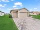 Paver driveway leading to a home with a three-car garage and well-manicured lawn at 4073 Sable Loop Dr, Lake Wales, FL 33859