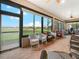 Screened lanai with multiple seating areas and views of a lake and landscaping at 4073 Sable Loop Dr, Lake Wales, FL 33859