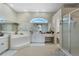 Bright bathroom featuring a soaking tub, vanity, walk-in shower, and large window at 415 Ruby Lake Pl, Winter Haven, FL 33884