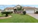 Beautiful single-story house with a well maintained lawn, palm trees, and an attached two-car garage at 415 Ruby Lake Pl, Winter Haven, FL 33884