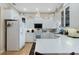 Bright kitchen featuring white cabinetry, modern appliances, quartz countertops, and tile flooring at 415 Ruby Lake Pl, Winter Haven, FL 33884