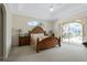 Large main bedroom featuring a carved wood bed frame and sliding door access to the pool at 415 Ruby Lake Pl, Winter Haven, FL 33884
