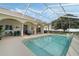Beautiful screened-in pool with clear blue water, patio seating, and manicured landscaping at 415 Ruby Lake Pl, Winter Haven, FL 33884