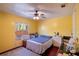 This bedroom features yellow walls, a ceiling fan, and a blue comforter at 428 Garrett Ridge Ct, Winter Haven, FL 33880