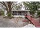 Inviting home featuring a screened porch, complemented by mature trees and unique ramp access at 428 Garrett Ridge Ct, Winter Haven, FL 33880