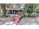 Charming property featuring a screened porch with seating, enhanced by a unique red ramp and lush foliage at 428 Garrett Ridge Ct, Winter Haven, FL 33880