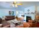 Living room with white walls, wood floors, brick fireplace, and leather furniture at 428 Garrett Ridge Ct, Winter Haven, FL 33880