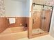 This bathroom featuring a shower with a glass door and bathtub at 4909 Fleetwood St, Lake Wales, FL 33859