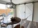 Charming dining area with a modern light fixture, sliding barn doors, and view to the backyard at 4909 Fleetwood St, Lake Wales, FL 33859