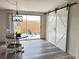 Bright dining area featuring sliding glass doors, modern light fixture, and a sliding barn door at 4909 Fleetwood St, Lake Wales, FL 33859