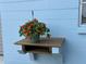 Charming exterior detail shows a hanging floral basket on a wooden shelf against a blue-painted wall at 4909 Fleetwood St, Lake Wales, FL 33859