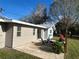 Rear exterior view of the home features a patio with comfortable seating and a well-maintained yard at 4909 Fleetwood St, Lake Wales, FL 33859