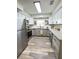 Modern kitchen featuring stainless steel appliances, gray cabinets, and granite countertops, updated flooring at 4909 Fleetwood St, Lake Wales, FL 33859