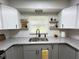 Well-lit kitchen sink area featuring stainless steel sink, granite countertops, and floating decor shelves at 4909 Fleetwood St, Lake Wales, FL 33859