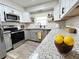 Charming kitchen featuring granite countertops, stainless steel appliances, and modern white and grey cabinetry at 4909 Fleetwood St, Lake Wales, FL 33859