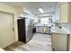 Well-lit kitchen showcasing stainless steel appliances, wood-look floors and white cabinetry with dark hardware at 4909 Fleetwood St, Lake Wales, FL 33859