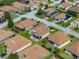 Drone eye view showcasing an elegant, light grey, single-story home with an attached 2 car garage at 5304 Nicklaus Dr, Winter Haven, FL 33884