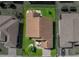 Drone eye view of a single-story home with a brown roof, green lawn, and a lovely patio area at 5304 Nicklaus Dr, Winter Haven, FL 33884