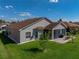 An aerial view shows a lanai and patio area in a well-maintained backyard surrounded by green lawn at 5304 Nicklaus Dr, Winter Haven, FL 33884
