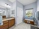 Stylish bathroom featuring a vanity with granite countertops, a large mirror, and a bench at 5304 Nicklaus Dr, Winter Haven, FL 33884