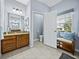 Bright bathroom with a vanity with granite countertops, and a bench beneath the window at 5304 Nicklaus Dr, Winter Haven, FL 33884