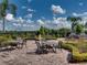 Brick courtyard with a fountain, multiple tables and chairs, and manicured landscaping at 5304 Nicklaus Dr, Winter Haven, FL 33884