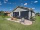 The enclosed patio features wicker furniture and a grill with brick flooring and views of the backyard at 5304 Nicklaus Dr, Winter Haven, FL 33884