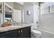 Bathroom with granite countertop, dark cabinets, and a shower-tub combination at 629 Copeland Dr, Haines City, FL 33844