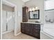 Bathroom featuring a walk-in shower and single vanity with granite countertops and dark wood cabinets at 629 Copeland Dr, Haines City, FL 33844