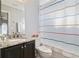 Modern bathroom with granite countertop, dark vanity, and a shower with a patterned curtain at 629 Copeland Dr, Haines City, FL 33844