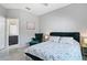 Comfortable bedroom featuring floral bedding, an accent chair, and access to the ensuite bathroom at 629 Copeland Dr, Haines City, FL 33844