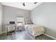 Well-lit bedroom with a modern desk, neutral decor, and wood-look tile flooring at 629 Copeland Dr, Haines City, FL 33844