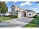 Charming two-story home featuring a well-manicured lawn and a paved driveway leading to the attached garage at 629 Copeland Dr, Haines City, FL 33844