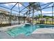 Inviting screened-in pool with a spa, lush landscaping, and clear blue water at 629 Copeland Dr, Haines City, FL 33844