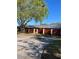 Charming home exterior featuring a well-maintained red fence, lush tree, and inviting walkway at 683 Broadmoor Cir # 683, Winter Haven, FL 33884