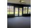 Enclosed lanai with neutral carpet, ceiling fan, and views of the outdoors through windows and sliding doors at 683 Broadmoor Cir # 683, Winter Haven, FL 33884