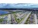 Expansive aerial view of a community with modern homes, a scenic lake, and lush green spaces creating a serene environment at 708 Simone Ct, Haines City, FL 33844