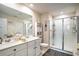 Bright bathroom featuring double sinks, a toilet, and a glass-enclosed shower with white subway tile at 708 Simone Ct, Haines City, FL 33844