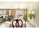 Dining room with a wooden table set for a meal, neutral wall colors, and access to the backyard at 708 Simone Ct, Haines City, FL 33844