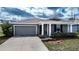 Beautiful single-Gathering home featuring a well-maintained lawn, two-car garage, and inviting entry at 708 Simone Ct, Haines City, FL 33844