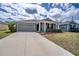 Inviting home with a two-car garage, tidy front lawn, and a welcoming entryway with decorative shrubbery at 708 Simone Ct, Haines City, FL 33844