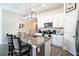Stylish kitchen featuring an island with bar seating, modern lighting, and stainless steel appliances at 708 Simone Ct, Haines City, FL 33844
