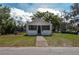 Quaint, one-story home featuring a traditional facade, screen front porch, and a walkway leading to the entrance at 750 Avenue O Sw, Winter Haven, FL 33880
